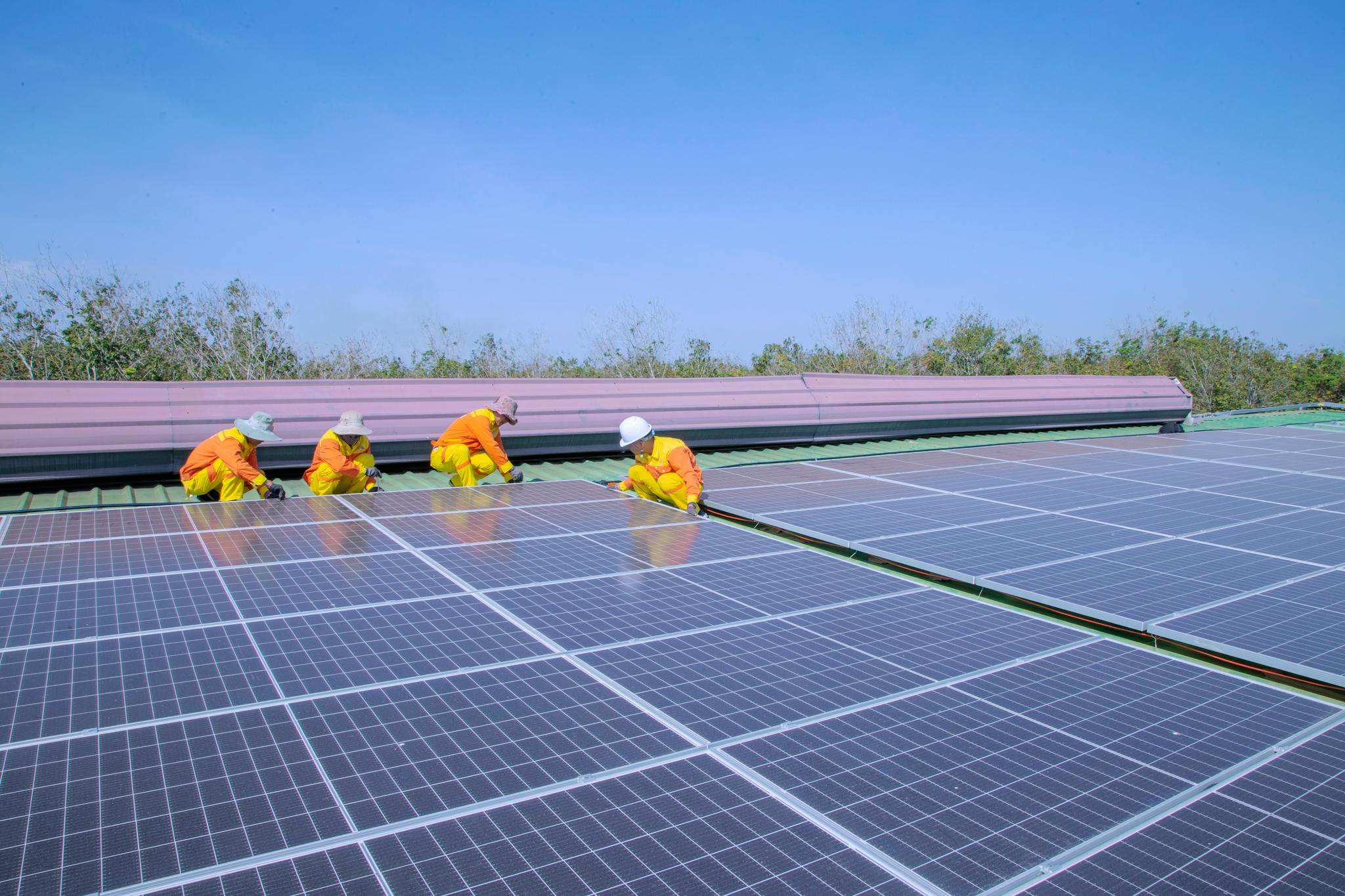 Workers installing solar panels on a sunny day, promoting renewable energy and sustainability.